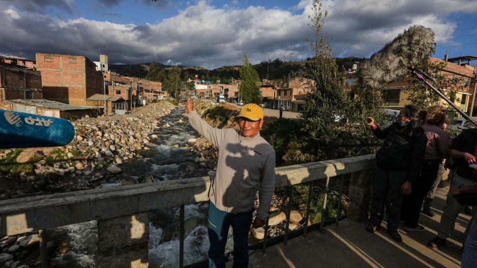Saúl Luciano Lliuya stands on a bridge that spans two rivers
