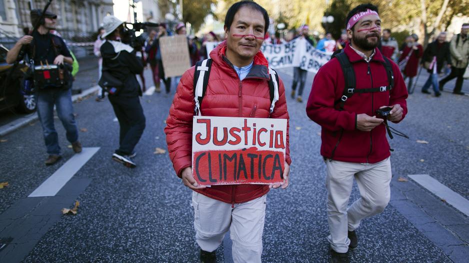 Saúl Luciano Lliuya at a demonstration with a sign "Justicia Climatica" (in English: climate justice)