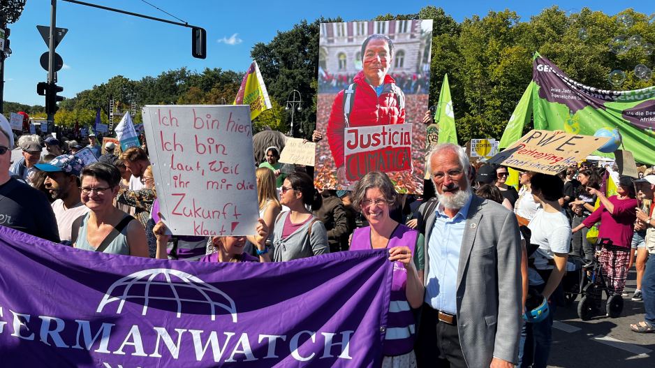 Mehrere Personen mit einem Banner von Germanwatch und einem Schild mit der Aufschrift "Ich bin hier, Ich bin laut, weil ihr mir die Zukunft klaut". Im Hintergrund wird ein großes Bild von Saúl Luciano Lliuya hochgehalten.